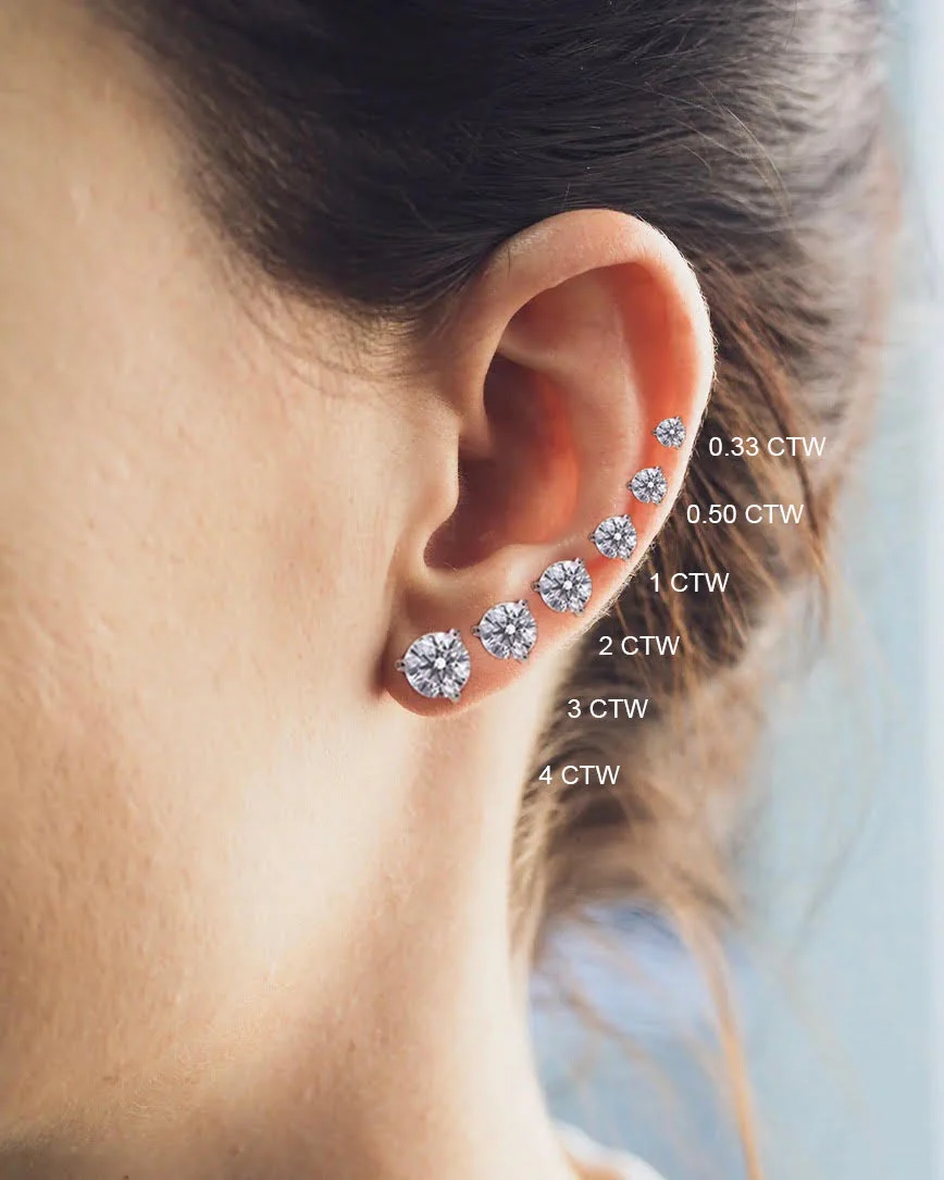 Round diamond stud earrings in sizes from 0.33 to 4 carats total weight shown along an ear